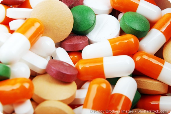 Pills of many shapes and colors grouped together